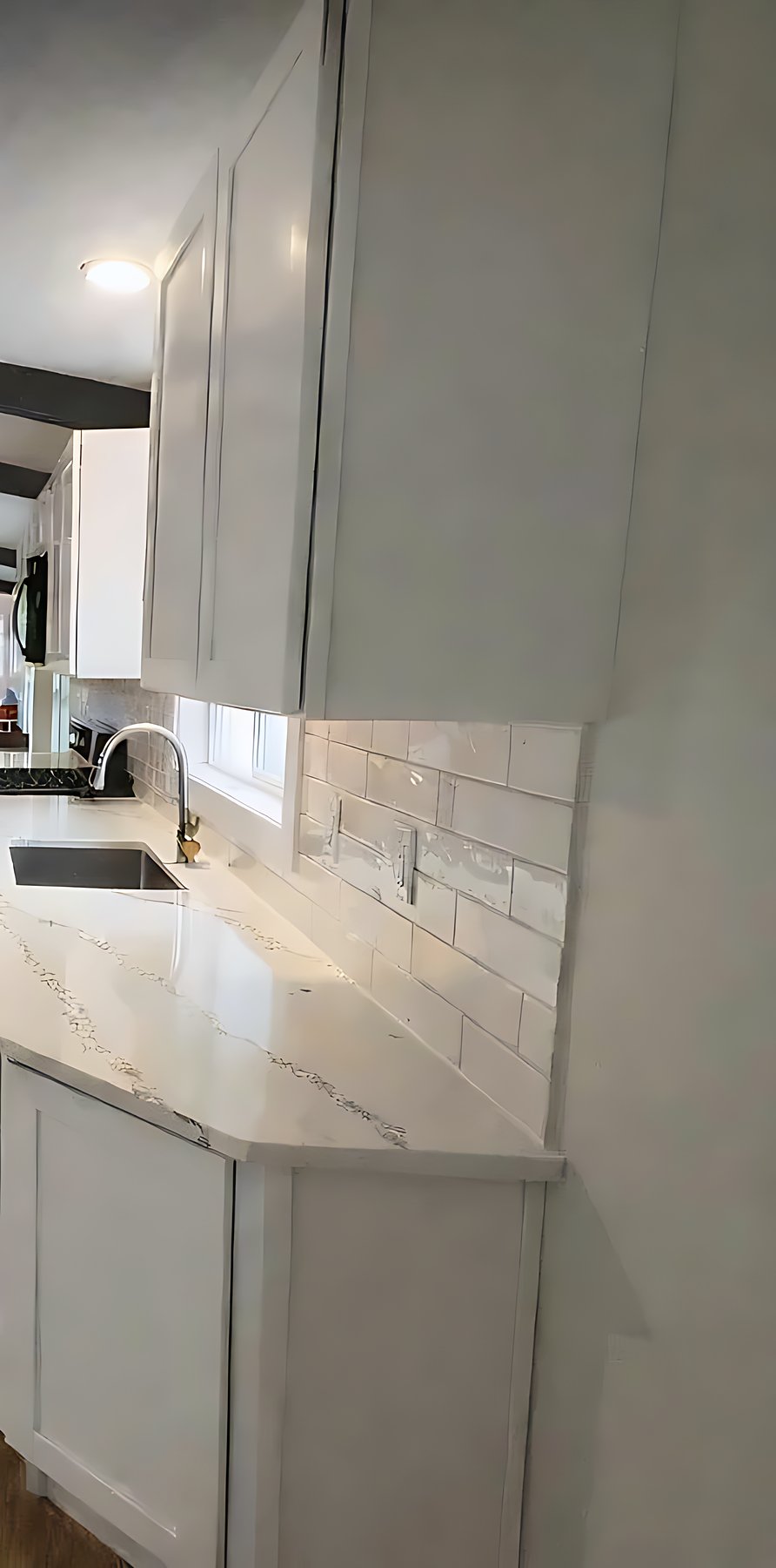 Finished kitchen beneath an exposed wood-beam ceiling